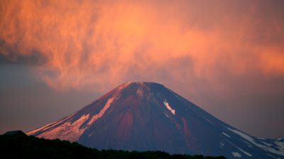 En vulkan med röd rökdimma över sig