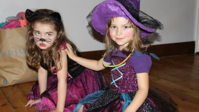 Två utklädda barn, en häxa och en katt