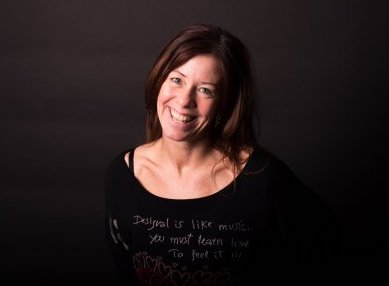 Närbild på Annika mot en svart bakgrund.