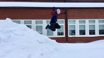 Foto på elev som hoppar i snöhög.