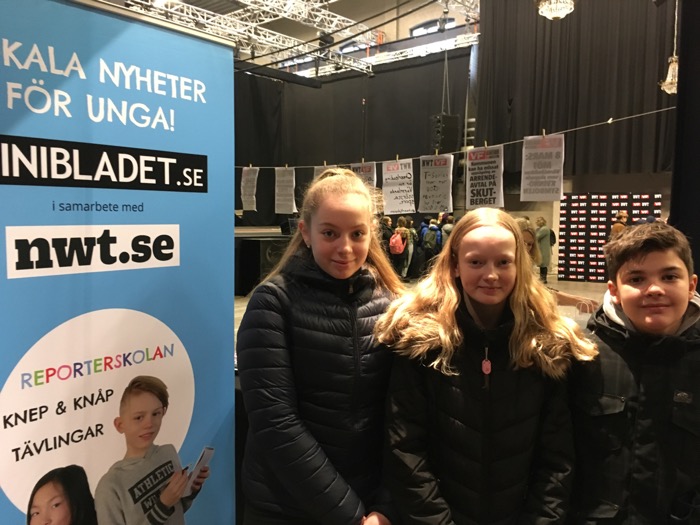 Tre barn vid en MiniBladet-affisch