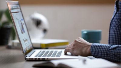 En person som sitter och skriver på en bärbar dator