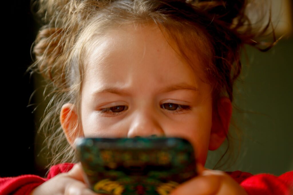 Flicka som tittar på telefonen.