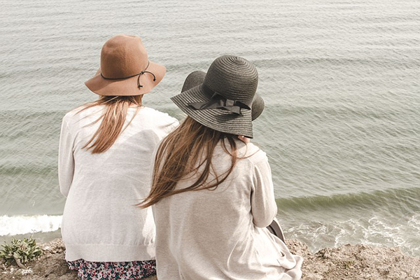 Två personer som sitter och tittar ut över havet.