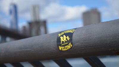Ett klistermärke där det står Refugees welcome