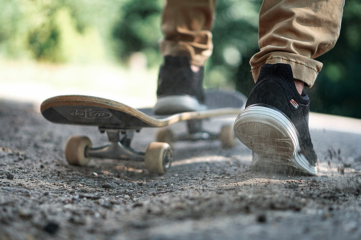 Närbild på en person som tar fart på en skateboard.