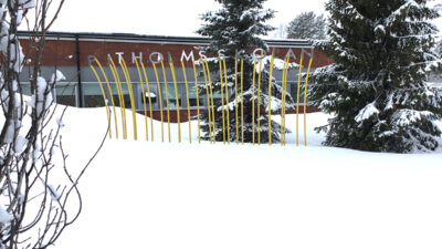 Bokstäver som bildar namnet Pitholmsskolan står på stänger i snön.