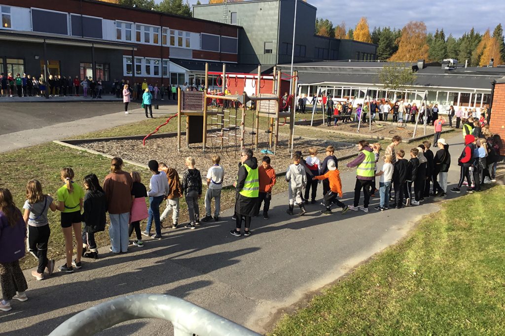 Skolans elever är samlade i långa led på skolgården.