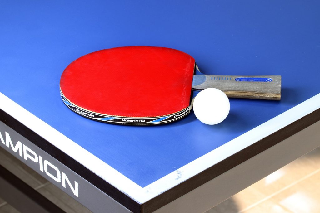 Bordtennisrack och boll på ett bord
