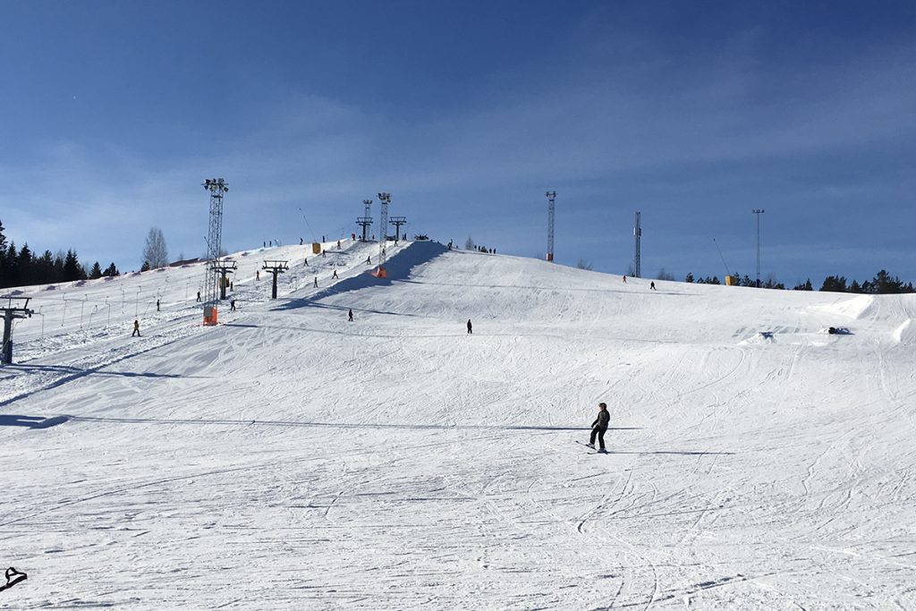 Vy över en skidbacke och blå himmel.